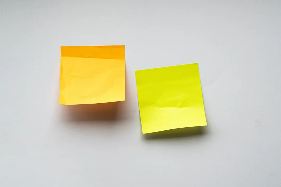 白い面に貼られた、まだ何も書かれていないオレンジと黄色の付箋2枚。