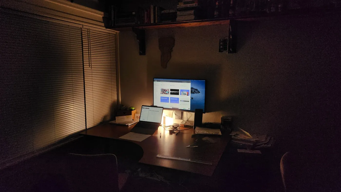 照明を落とした部屋の机に、画面のついたモニターとノートパソコンが置かれている。